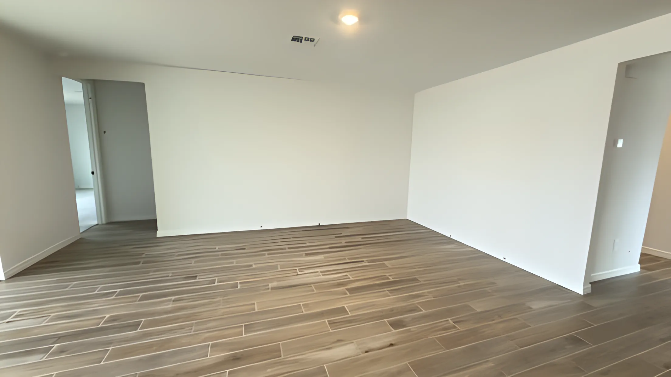 Gray wood-look vinyl plank flooring in a freshly finished empty room