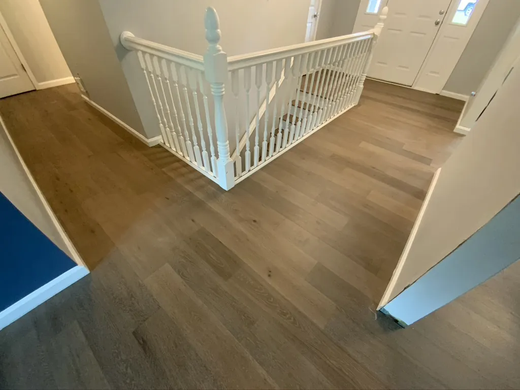 Hardwood flooring on an upstairs landing with white railing