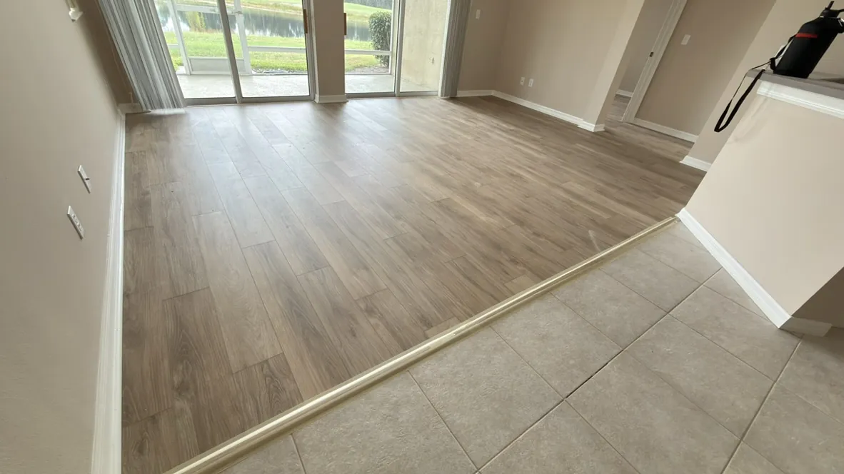 Vinyl plank flooring meeting existing tile at a clean transition line