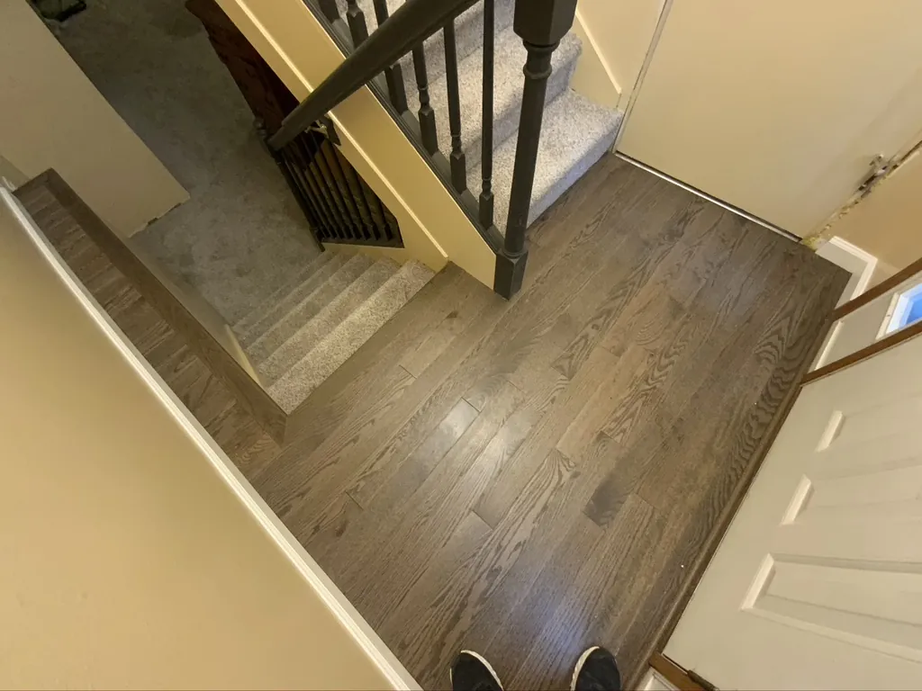 Hardwood flooring in an entry beside a staircase