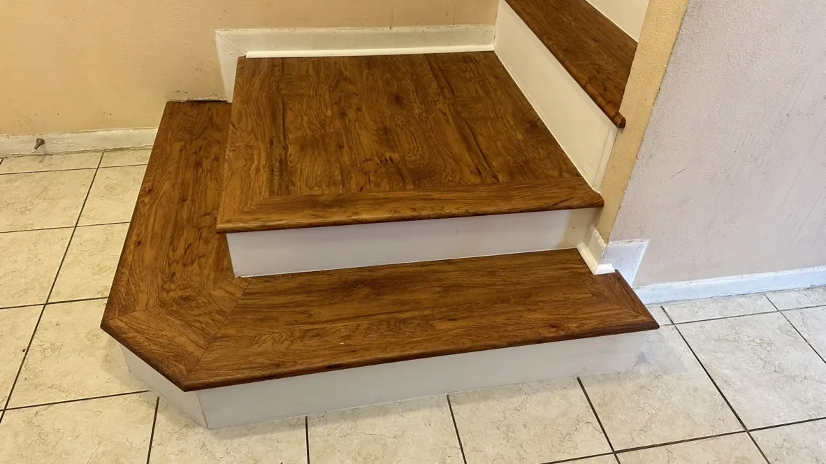 Finished wood stair treads meeting a tile transition